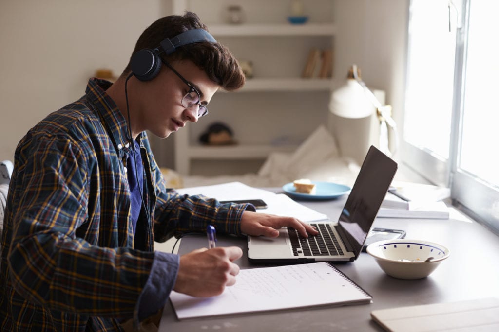 Estudiante aprendiendo con laptop y auriculares